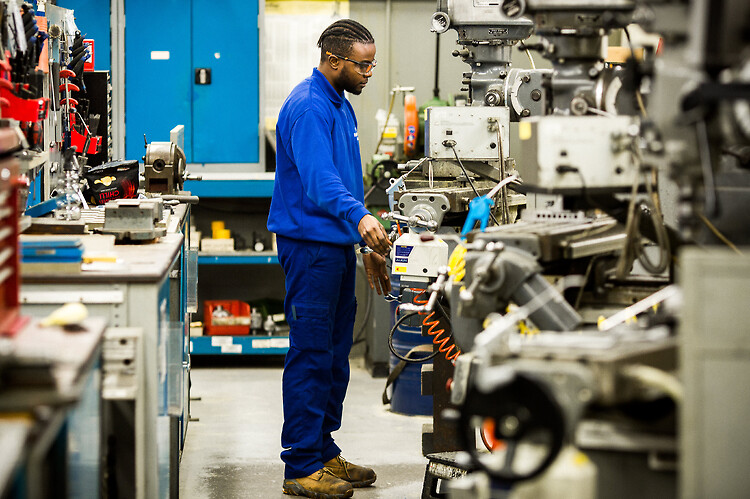 An engineer operating machinery on the shop floor.